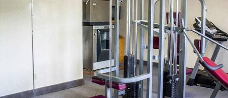 A gym with weight machines, a water dispenser, and a treadmill.