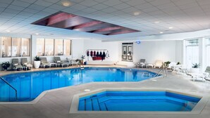 Une piscine intérieure dotée de plusieurs couloirs de nage, de chaises longues et d’un vestiaire avec casiers.