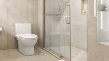 A modern bathroom with a toilet, a glass-enclosed shower, and a tiled floor.