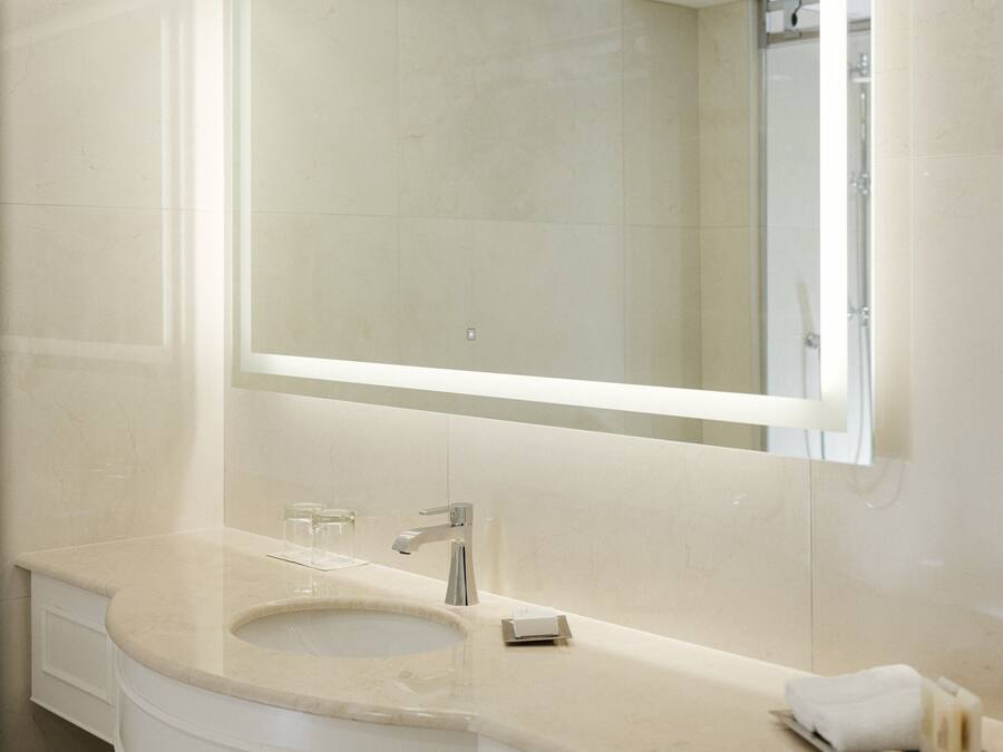 A modern bathroom with a large mirror, a sink, and a vanity.
