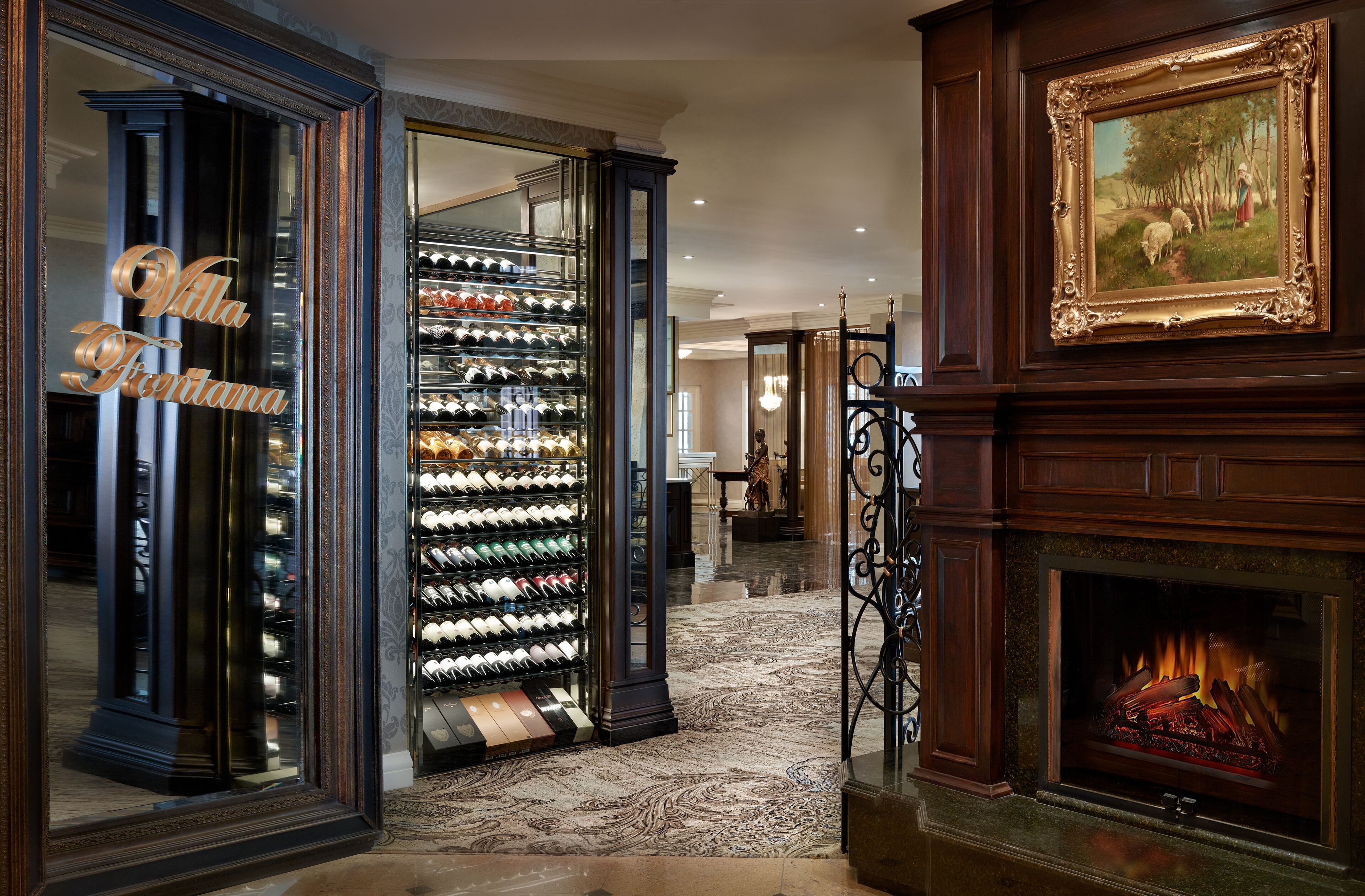 A wine cellar with a large wine rack, a fireplace, and a framed painting on the wall.