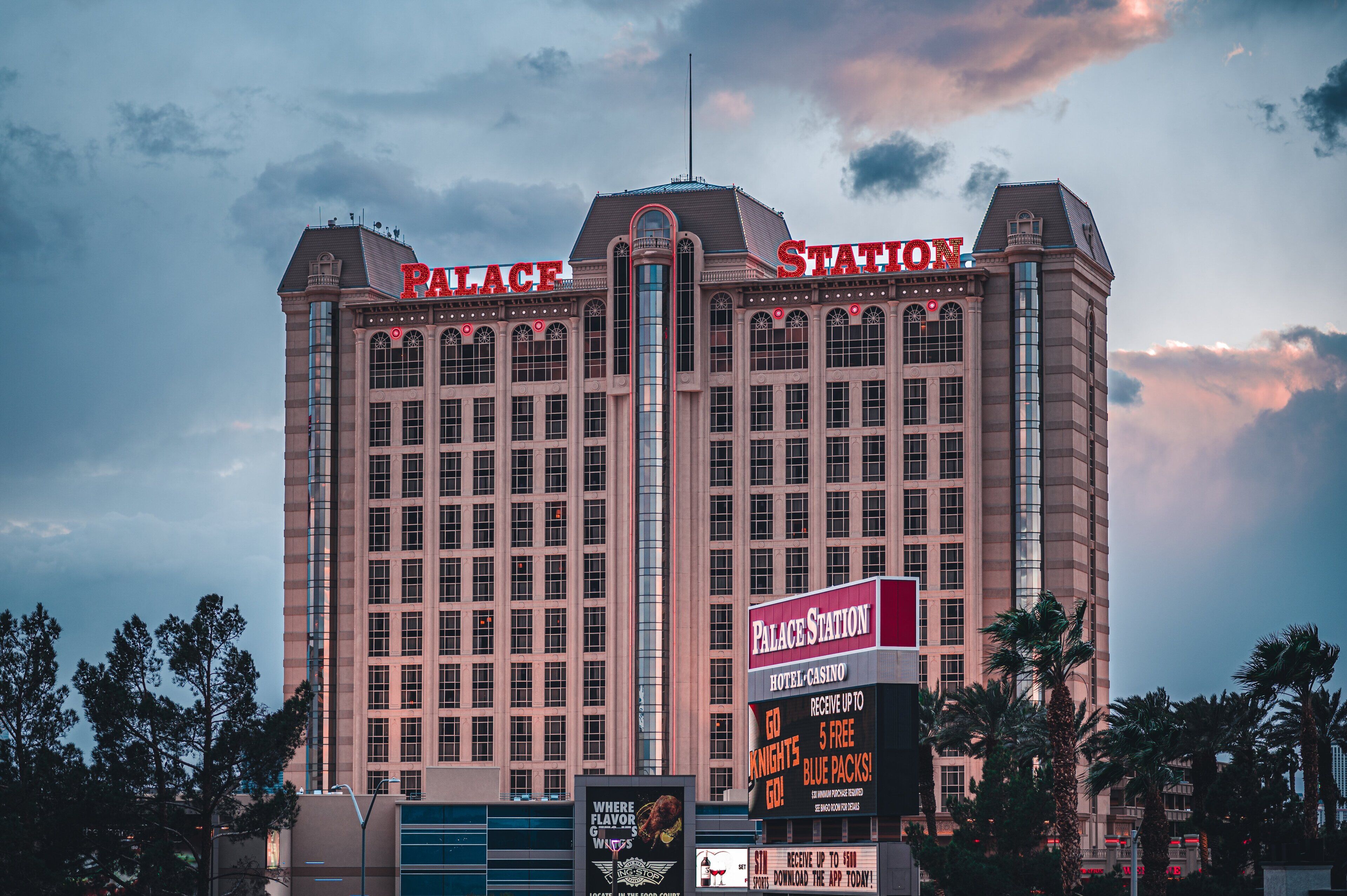 Un hotel grande con un letrero llamativo que dice "Palace Station Hotel-Casino".