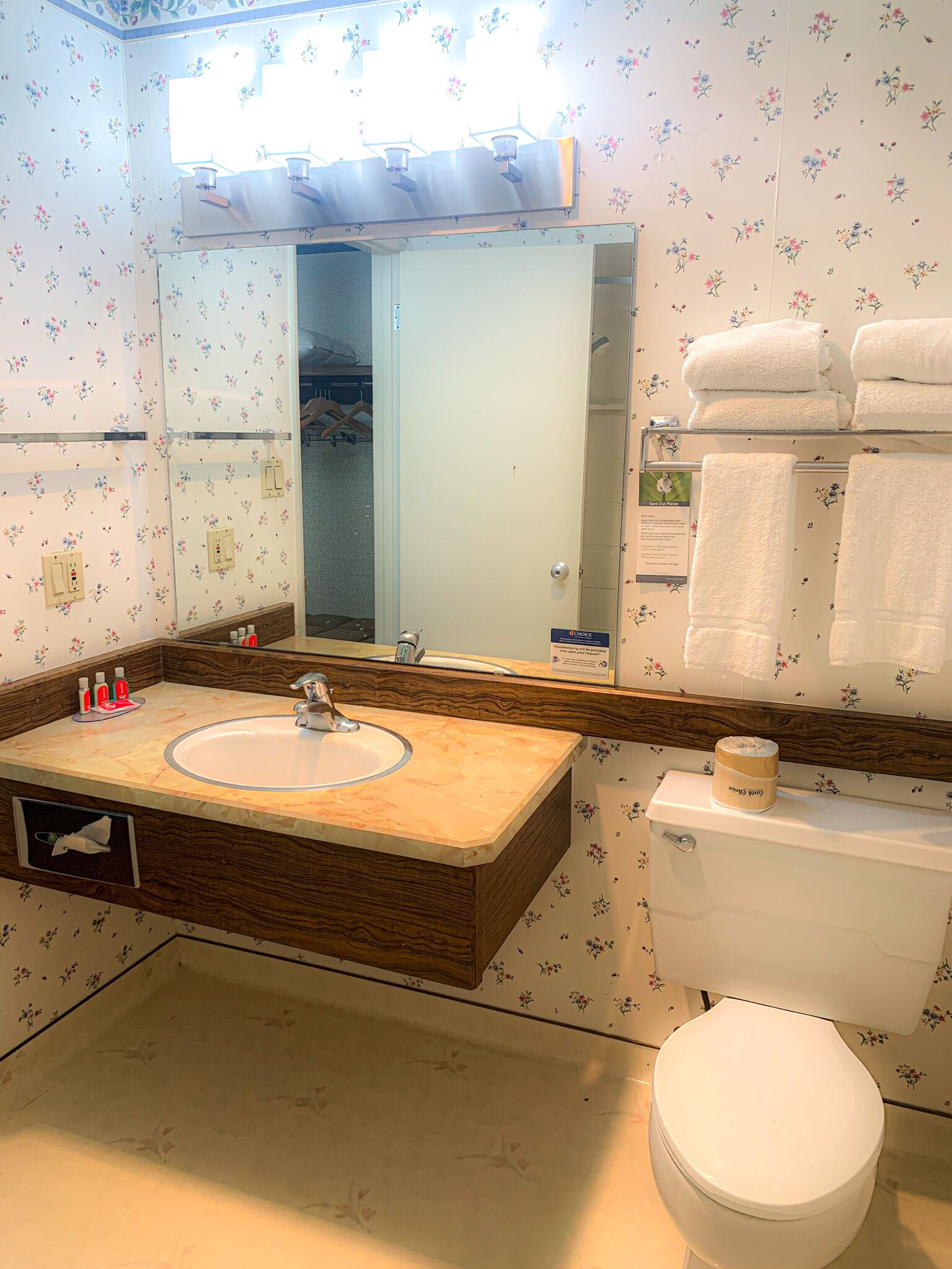 Un baño con lavamanos, espejo y retrete.