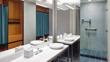 Un baño moderno con dos lavabos, un espejo grande y una zona de ducha.
