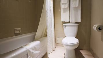 Een badkamer met een bad, toilet en douchegordijn.