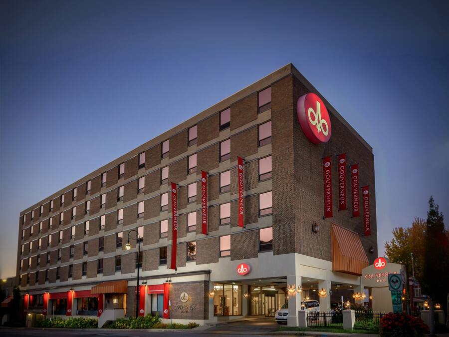 A hotel with a prominent red logo, multiple windows, and red banners.