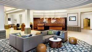 A modern lobby with a reception desk, seating area, and a patterned floor. - DoubleTree by Hilton Nashua (Nashua)
