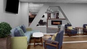 A modern lounge area with sofas, armchairs, a coffee table, and a fireplace. - Residence Inn by Marriott White Plains Westchester County (White Plains)