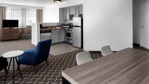 A modern hotel room with a dining area, kitchenette, and a TV. - Residence Inn by Marriott White Plains Westchester County (White Plains)