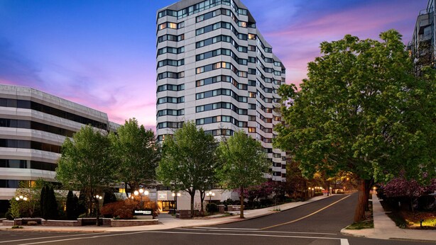 A modern high-rise hotel with a curved facade, multiple floors, and a well-lit entrance. - Residence Inn by Marriott White Plains Westchester County (White Plains)