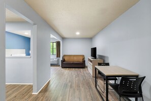 Un salon moderne avec un canapé, un téléviseur et un coin repas.