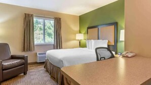 Une chambre d’hôtel équipée d’un lit, d’un bureau, d’une chaise, d’une lampe et d’un téléphone.