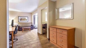 Une chambre d’hôtel équipée d’un bureau, d’une chaise, d’un canapé et d’une armoire.