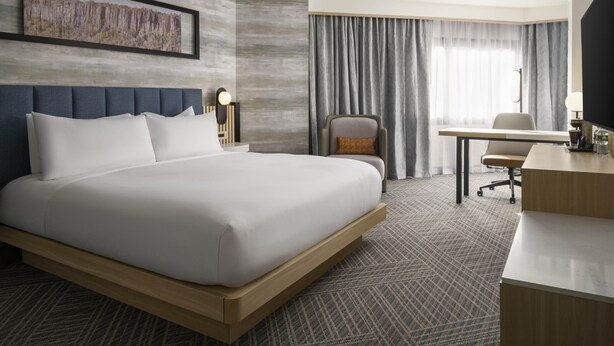 A modern hotel room with a large bed, a desk, and a chair. - DoubleTree by Hilton Fort Lee - George Washington Bridge (Fort Lee)