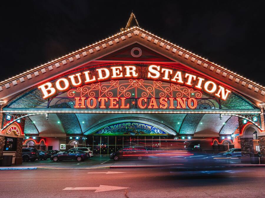 The exterior of Boulder Station Hotel & Casino with illuminated signage and a prominent archway.