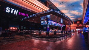 Un bar deportivo con varias pantallas, una zona de bar y una sección de asientos.