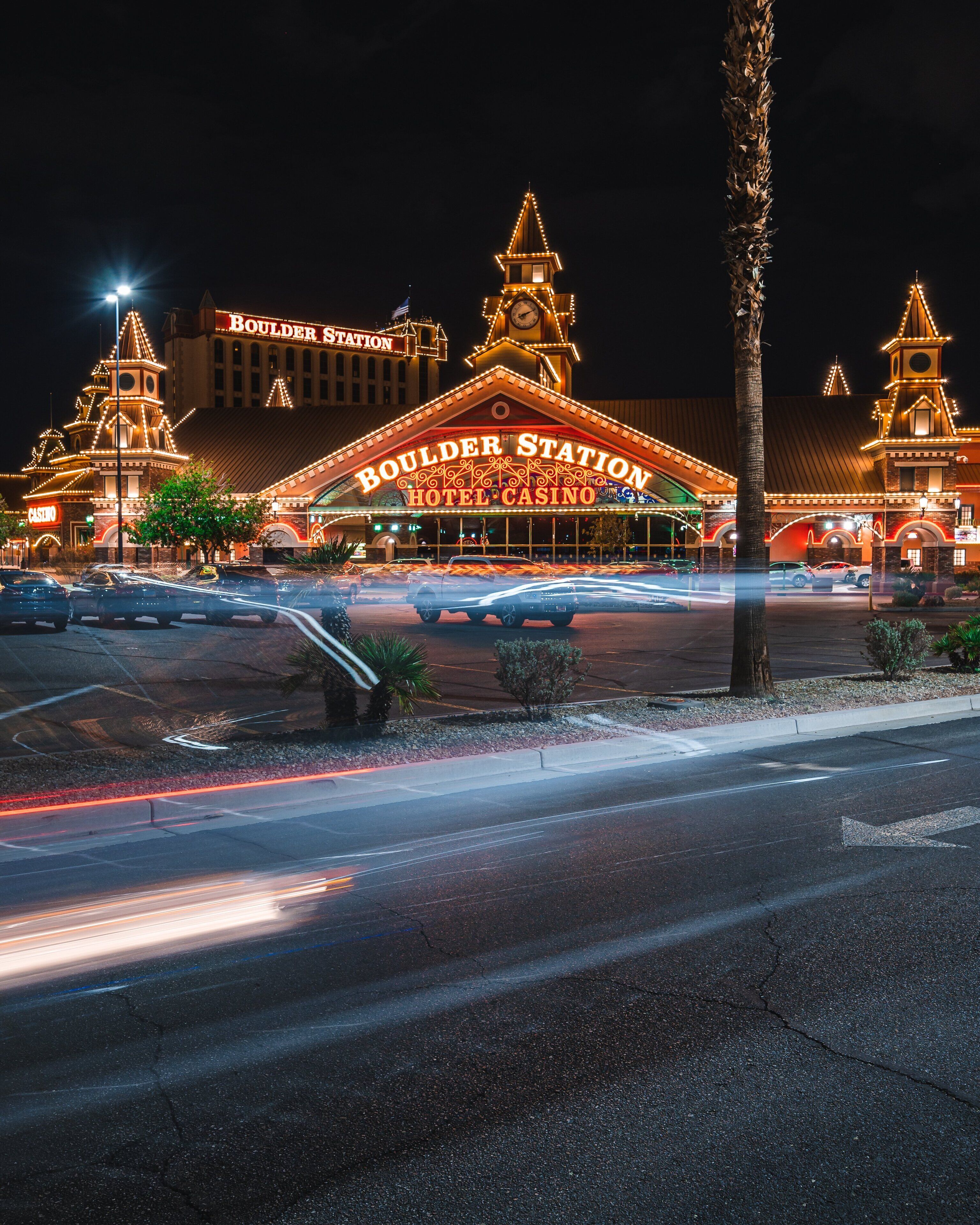 Exterior del Hotel & Casino Boulder Station con señalización iluminada y una imponente torre de reloj.