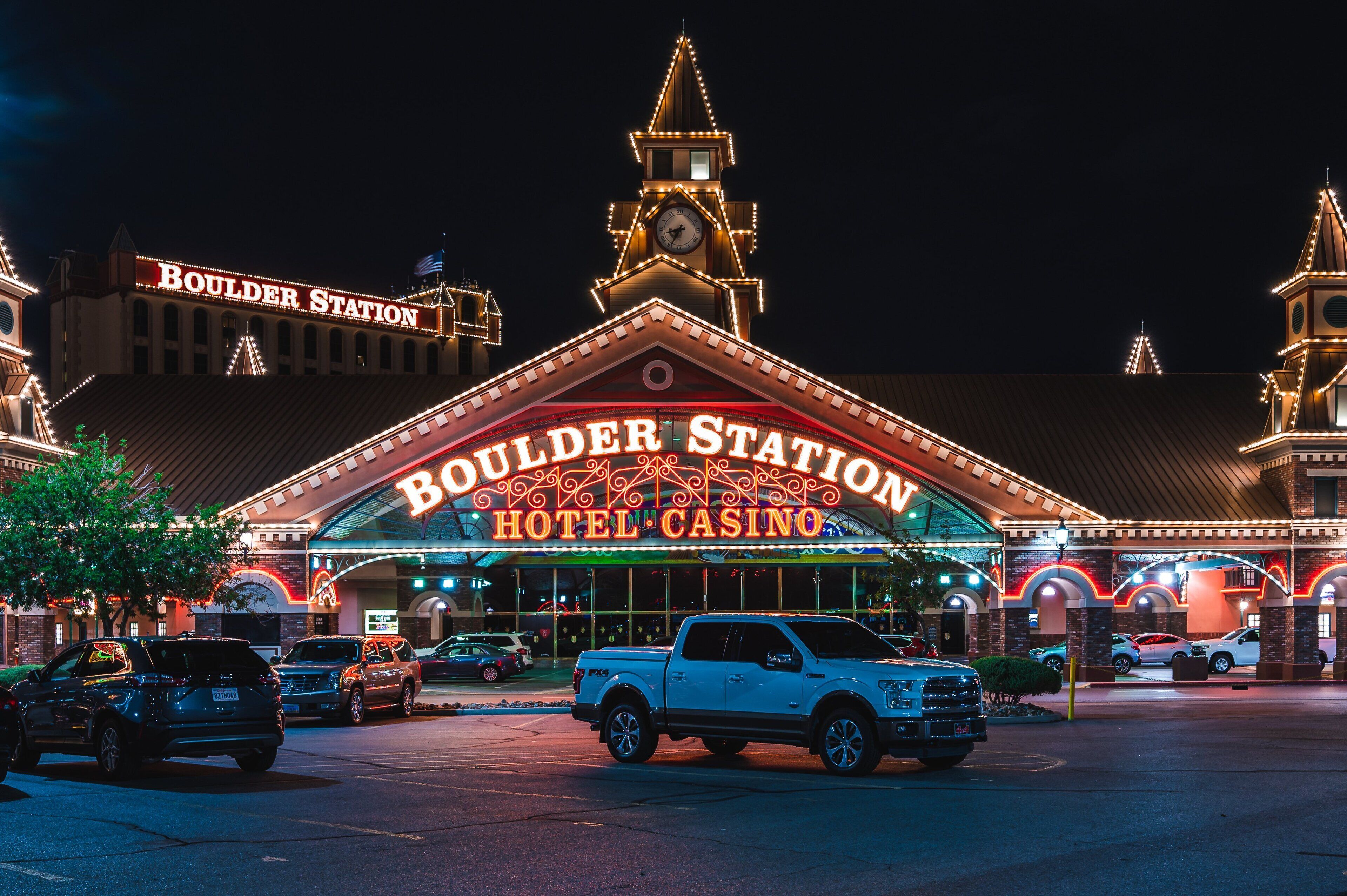 Um hotel/cassino com uma placa grande que diz "BOULDER STATION HOTEL CASINO".