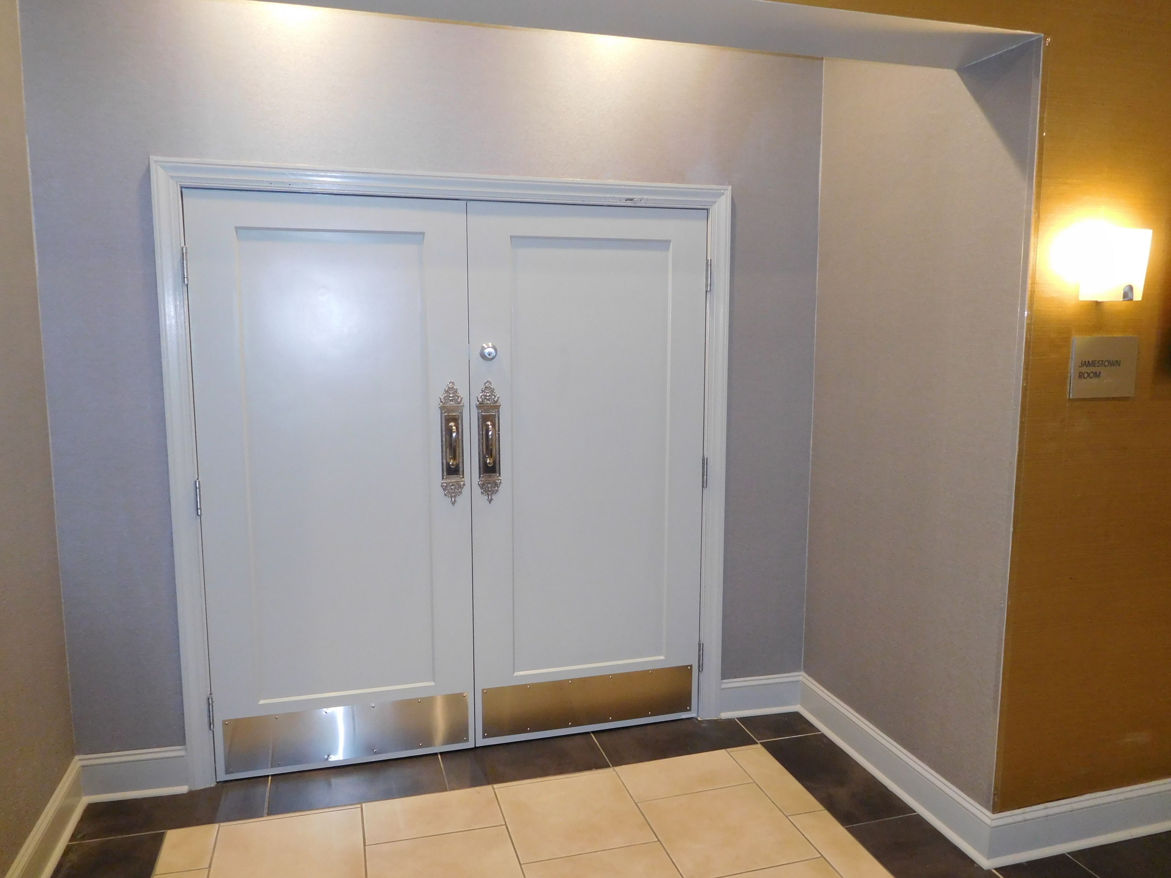 Una puerta doble blanca con un cartelito encima que dice "JAMESVILLE ROOM".