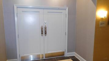 Una puerta doble blanca con un cartelito encima que dice "JAMESVILLE ROOM".