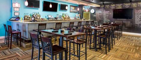 Een bar met een toonbank, barstoelen en een menukaart.