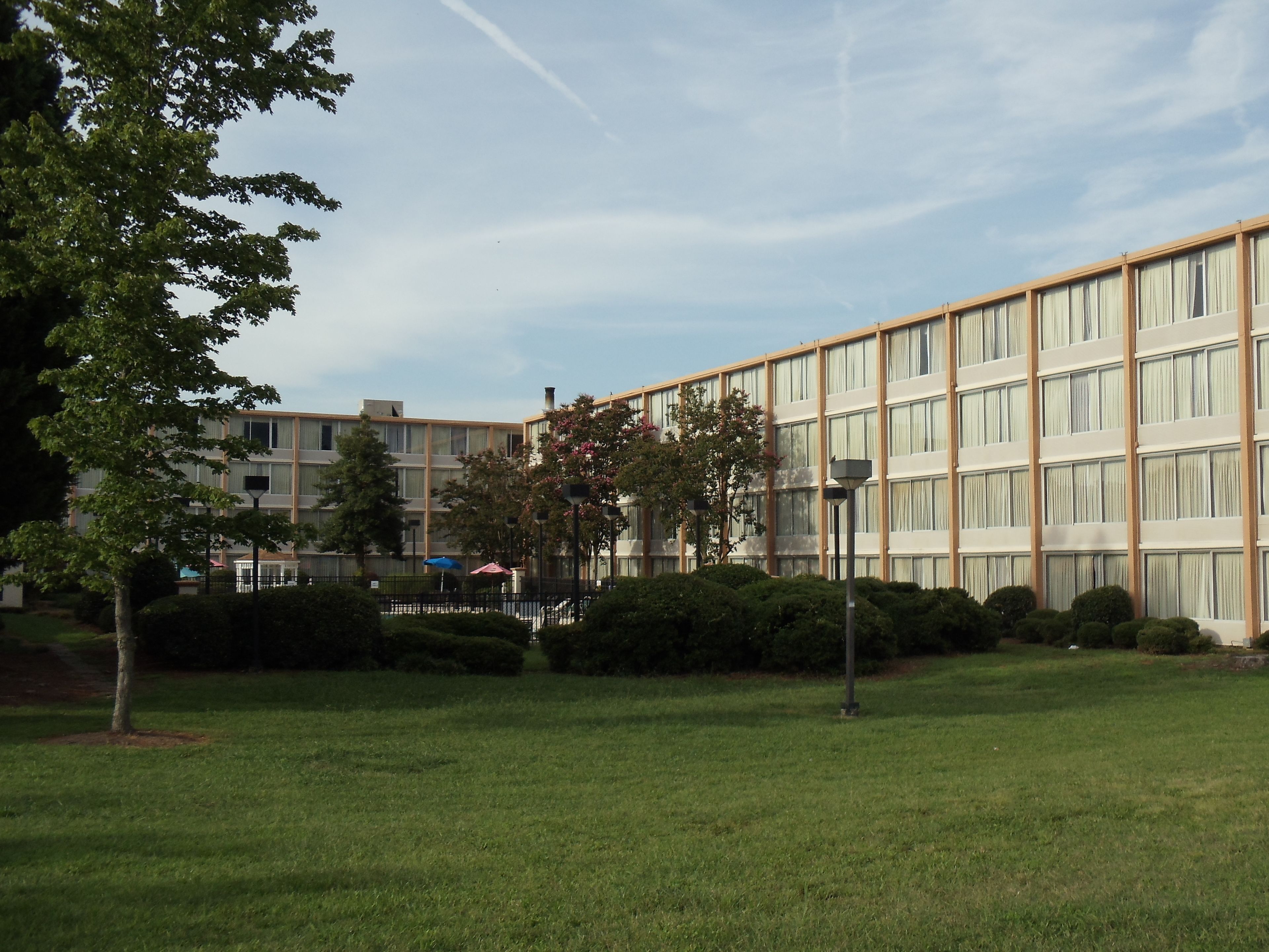 Un edificio de varios pisos con un diseño arquitectónico moderno, que cuenta con una serie de ventanas y un techo plano.