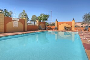 Relax by the pool surrounded by lounge chairs and tables.