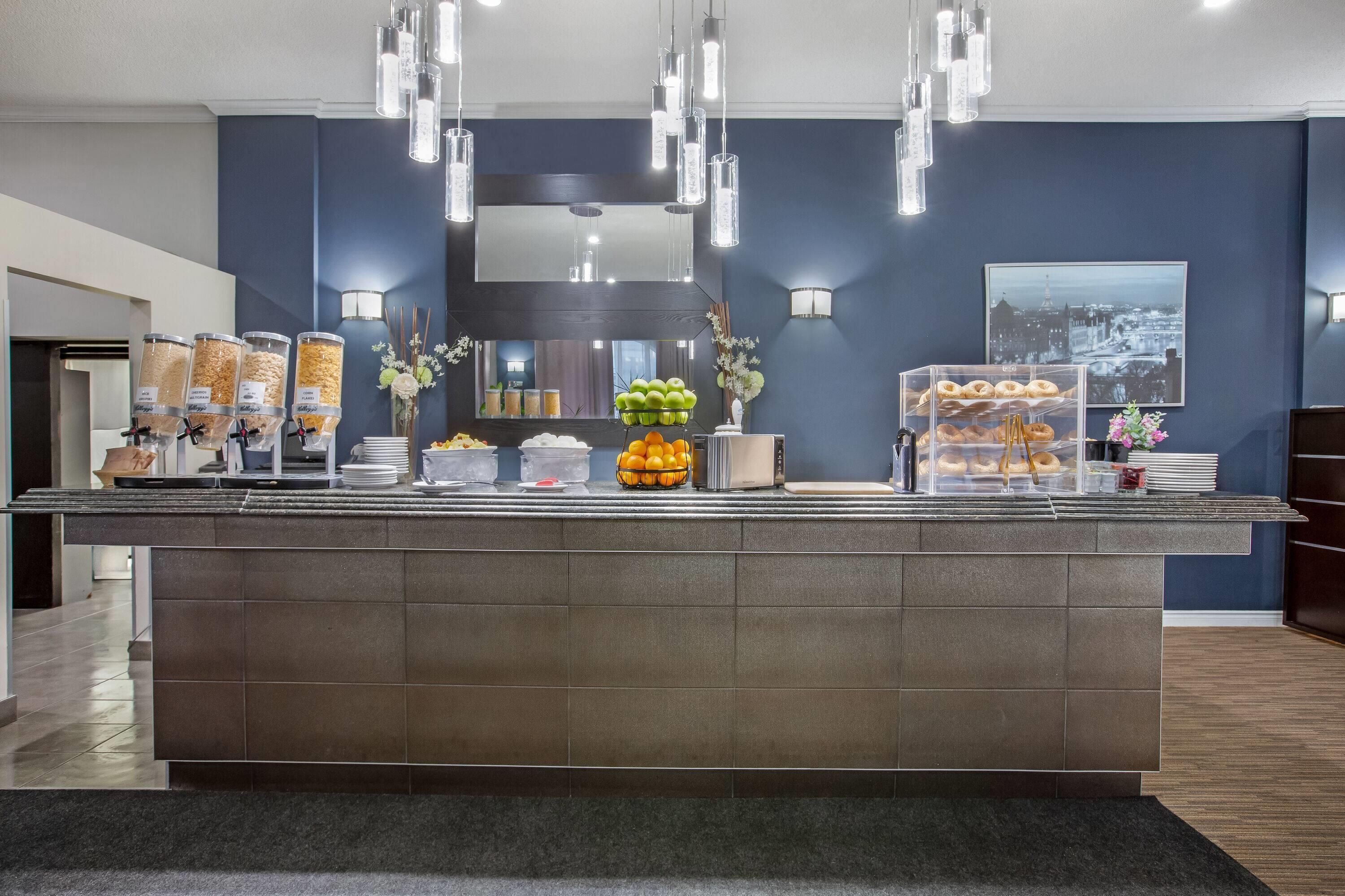 Un área de recepción con un mostrador que exhibe alimentos, un espejo e iluminación en la pared.