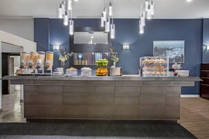 A reception area with a counter displaying food items, a mirror, and wall-mounted lights.