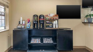 A coffee station with two coffee makers, a selection of coffee pods, and a beverage dispenser.