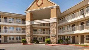 A multi-story hotel with a central lobby, balconies, and a stone facade.