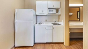 A compact kitchenette with a refrigerator, microwave, and basic countertop appliances.