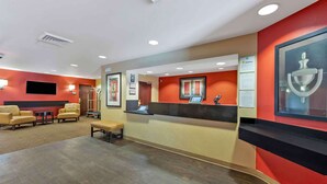 A reception area with a counter, seating, and a television.