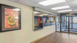 A reception area with a framed artwork, a reception desk, and a glass door entrance. - Extended Stay America Select Suites Chicago Downers Grove (Downers Grove)