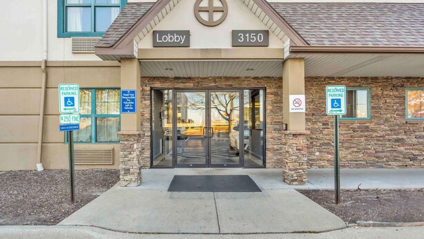 A building entrance with a 'Lobby' sign, '3150' address, reserved parking signs, and a no parking sign. - Extended Stay America Select Suites Chicago Downers Grove (Downers Grove)