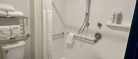 Un baño moderno con ducha, inodoro y perchero para toallas.
