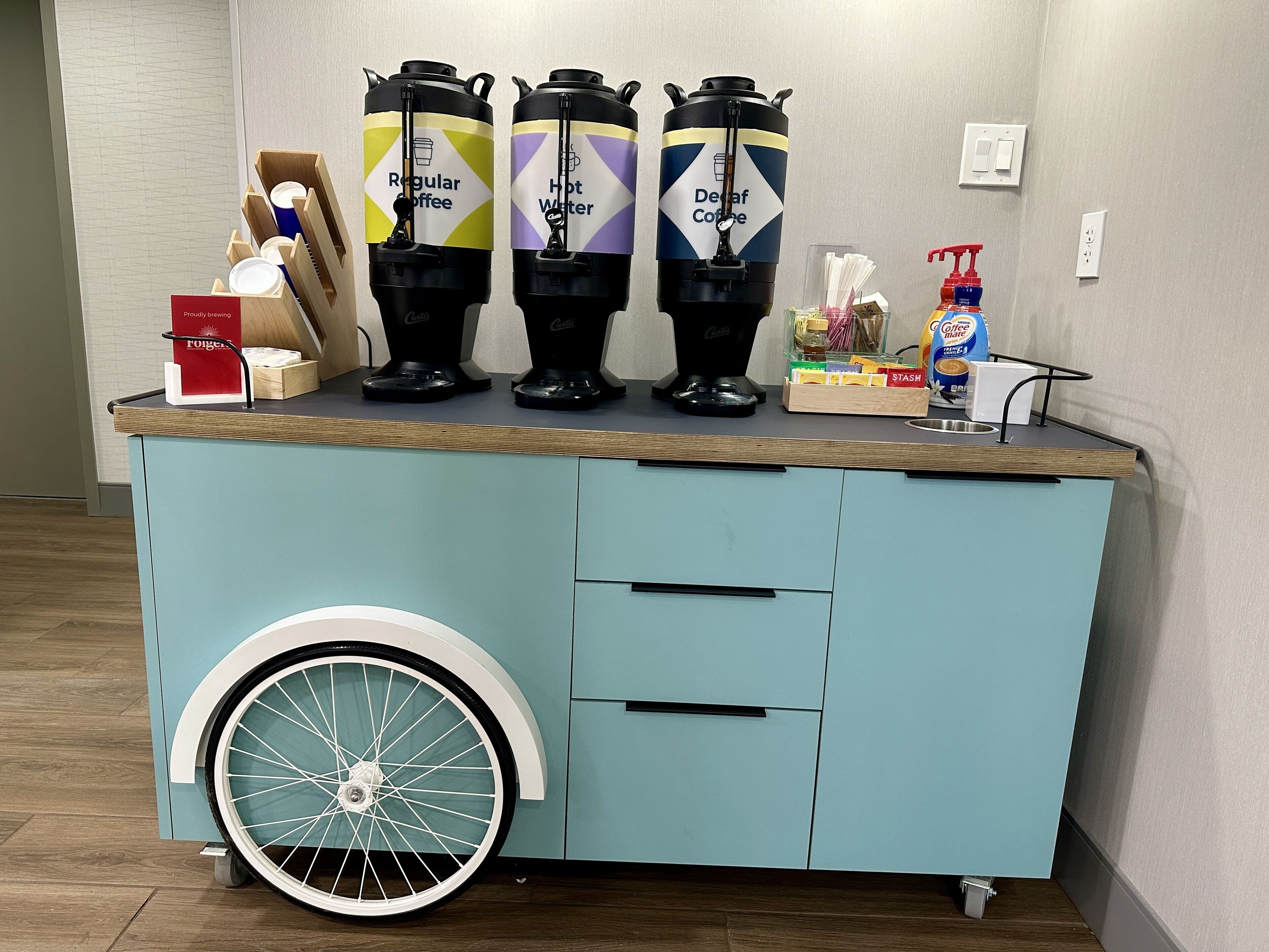 A coffee station with three dispensers labeled "Regular Coffee," "Hot Water," and "Decaf Coffee."