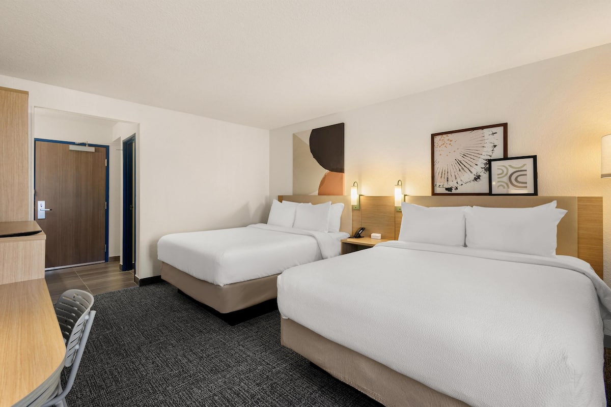 Escritorio, cortinas blackout y tabla de planchar con plancha