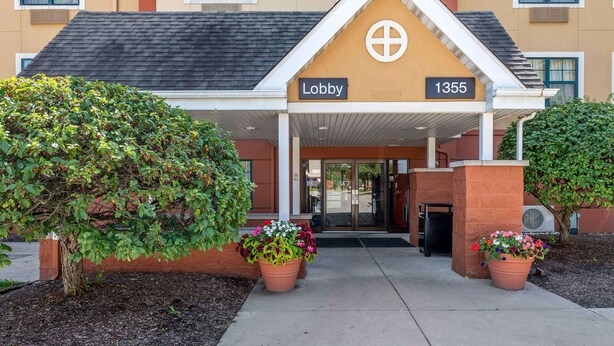 Ein Hotel Eingang mit einem 'Lobby'-Schild, der Nummer '1355' und Zimmerpflanzen.
