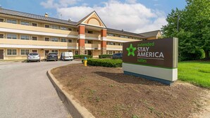 Un hotel Stay America Suites con un amplio estacionamiento y un cartel.