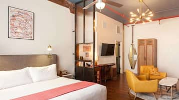 Une chambre d’hôtel équipée d’un lit, d’un bureau, d’une chaise, d’une télévision et d’un ventilateur de plafond.
