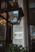 A vintage street lamp and a sign for "The Old No. 77 Hotel & Chandelier" on a building facade.