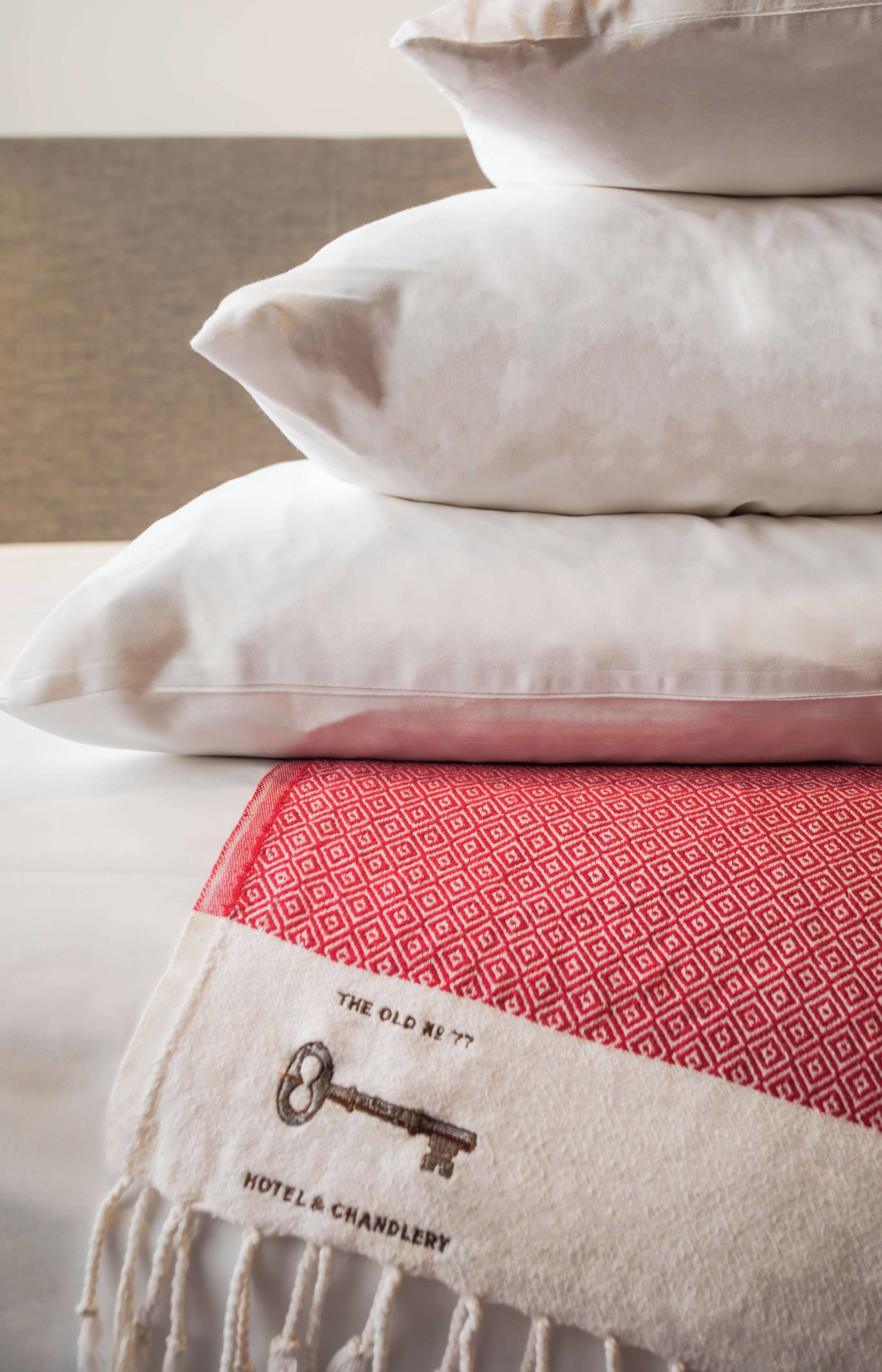 A stack of pillows and a blanket with a key and text on it.