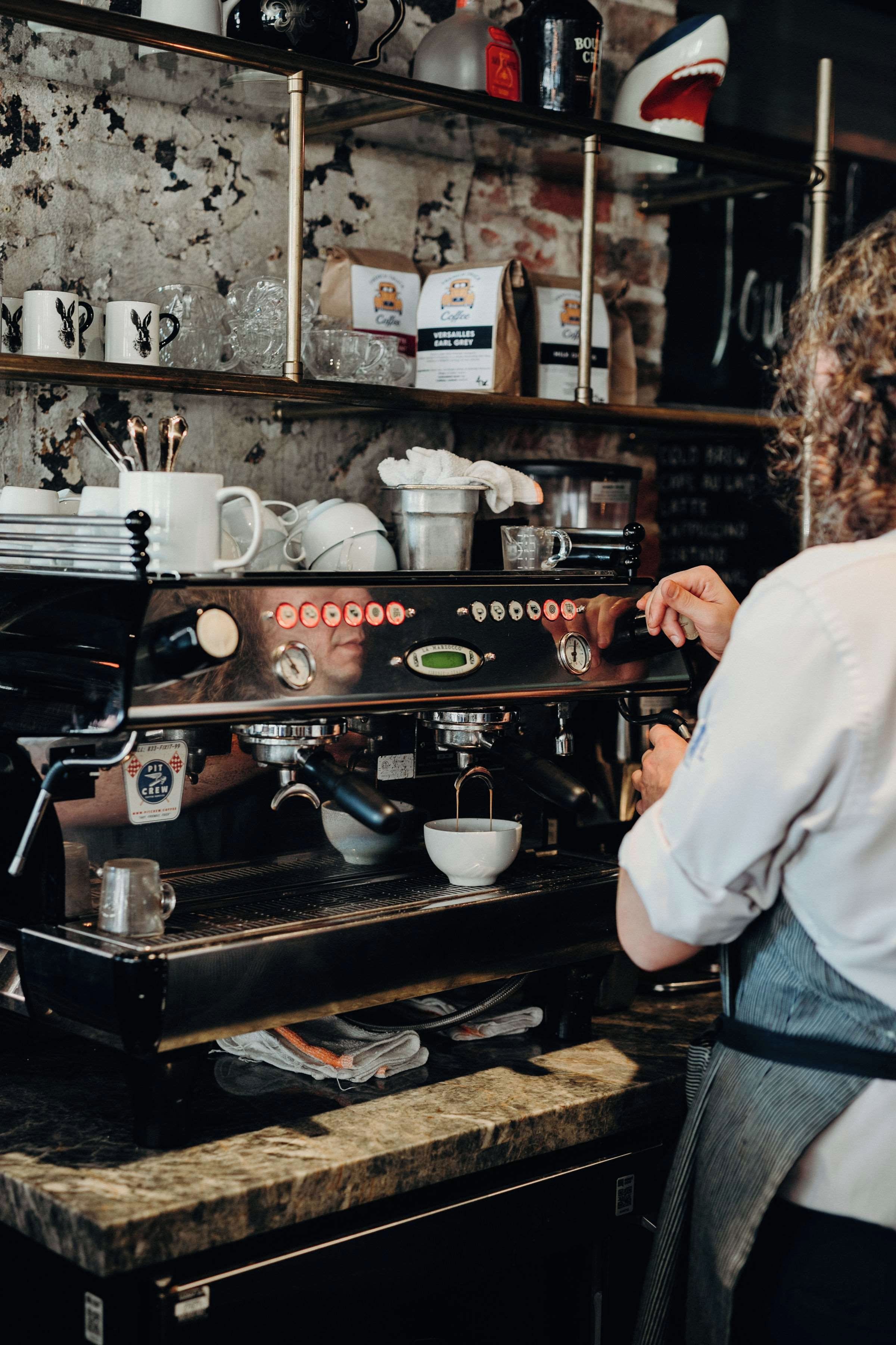 Un barista préparant du café à l’aide d’une machine à expresso professionnelle.