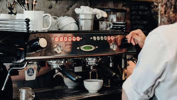 Un barista préparant du café à l’aide d’une machine à expresso professionnelle.
