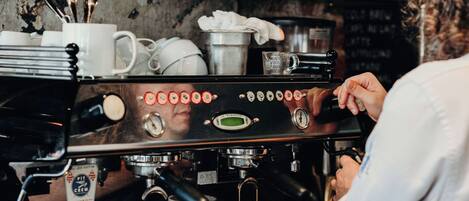 A barista preparing coffee at a commercial espresso machine.