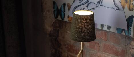 A wooden desk with a lamp, a book, and a chair.