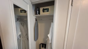 Un cabina armadio con vesti appese e un appendiabiti.