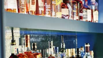 A bar with multiple shelves of various liquor bottles.