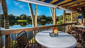 A wooden deck with a table and chairs overlooking a lake.